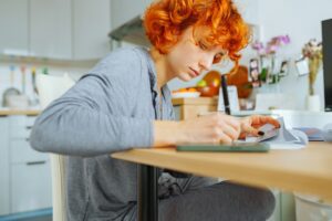 portrait attractive teenage girl filling out paper form